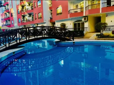 a bridge over a swimming pool in front of a building at Desert Pearl Studio Retreat in Hurghada