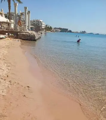 a person standing in the water on a beach at Desert Pearl Studio Retreat in Hurghada