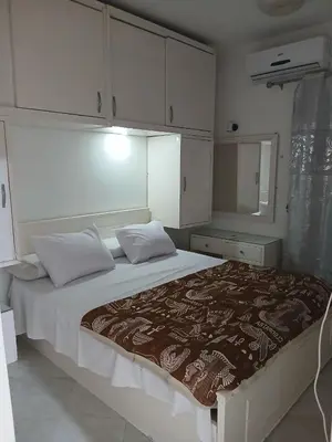 a bedroom with a large bed with white cabinets at Family apartment in front of the sea in Hurghada