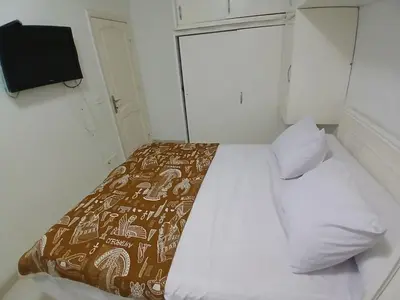 a bedroom with a bed with a blanket and a tv at Family apartment in front of the sea in Hurghada