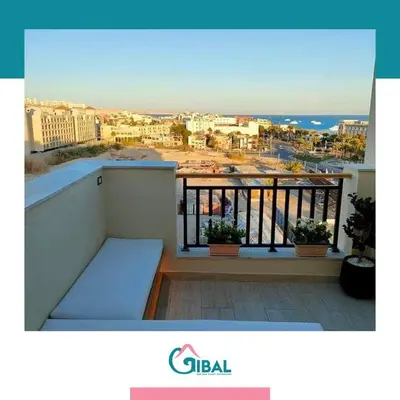 a balcony with a view of a city and the ocean at Chalet in Hurghada