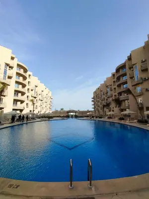 a large blue swimming pool in front of some buildings at Princess Resort, Hurghada in Hurghada