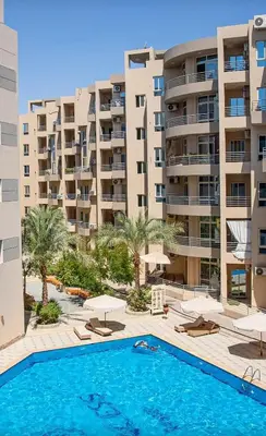 a swimming pool in front of a large apartment building at Princess Resort, Hurghada in Hurghada
