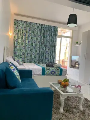 a room with a bed and a couch and a table at Azzura Sahl Hasheesh in Hurghada