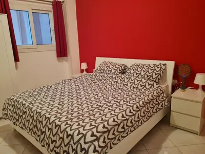 a bedroom with a bed with a black and white comforter at Oasis Resort Soraya - 2 bed apt, recently renovated and fully furnished with pool views in Al Ahyaa Hurghada Egypt in Hurghada
