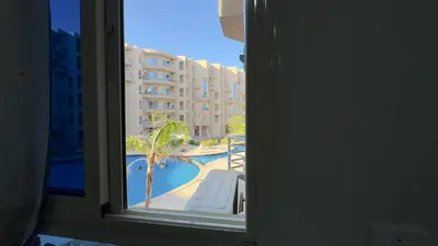 a view of a pool from a hotel room window at El princess one bedroom hurghada in Hurghada