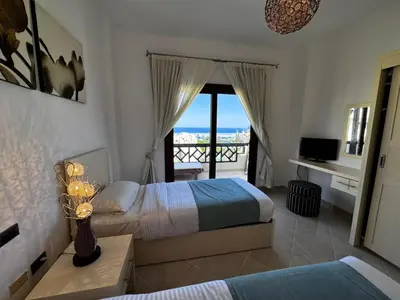 a bedroom with two beds and a view of the ocean at Gravity Apartments Sea View Pool View للأجانب فقط Just For Foreigners in Hurghada