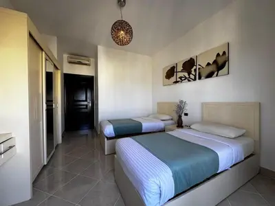 a bedroom with two beds and a hallway at Gravity Apartments Sea View Pool View للأجانب فقط Just For Foreigners in Hurghada