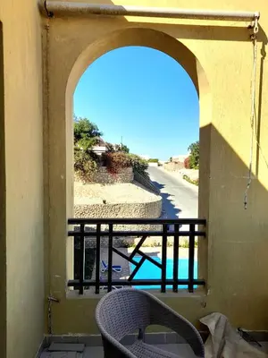 a balcony with a chair and a view of a pool at استديو ايجار في الغردقه 206 in Hurghada