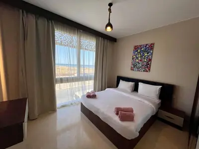 a bedroom with a bed and a large window at SunShine M9 Mangroovy in Hurghada
