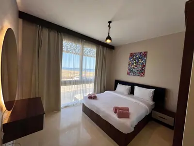 a bedroom with a bed and a large window at SunShine M9 Mangroovy in Hurghada