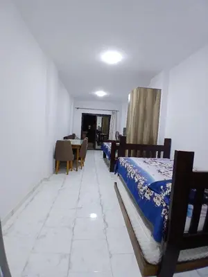 a bedroom with two beds and a dining room with a table at Studio in turtels beach e41 in Hurghada