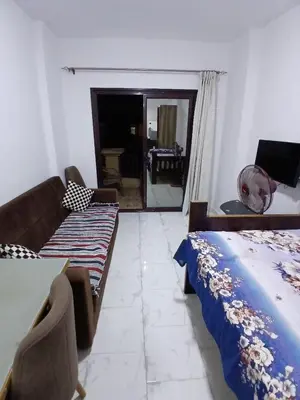a bedroom with a bed and a couch and a table at Studio in turtels beach e41 in Hurghada