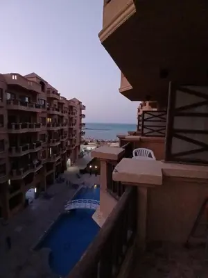 a view of a building with a swimming pool and the ocean at Studio in turtels beach e41 in Hurghada
