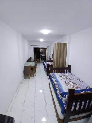 a bedroom with two beds and a table and a dining room at Studio in turtels beach e41 in Hurghada