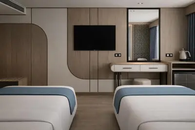 two beds in a room with a tv on the wall at Five-Stars Deluxe River Kruz from Aswan to Luxor 3 Nights in Aswān