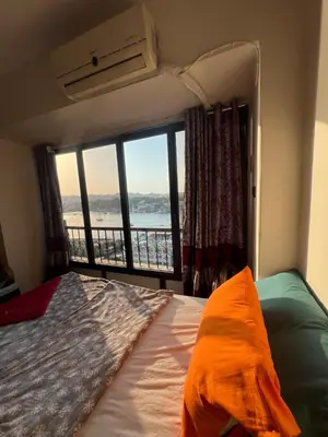a bedroom with a bed and a large window at NubaNest GuestHouse in Aswan