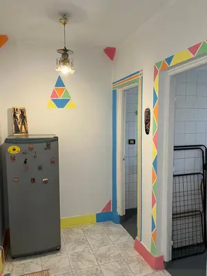 a room with a refrigerator and a colorful wall at NubaNest GuestHouse in Aswan