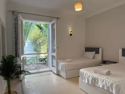 a bedroom with two beds and a large window at Hillside 4BR Villa, El Gouna Getaway in Hurghada