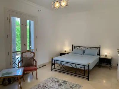 a bedroom with a bed and a chair and a table at Unique Hill Villa 3 BD In Gouna in Hurghada