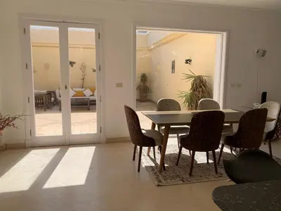 a dining room with a table and chairs and a patio at Unique Hill Villa 3 BD In Gouna in Hurghada