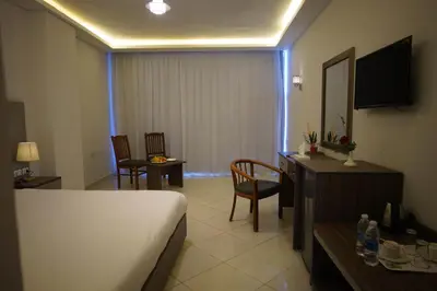 a hotel room with a bed and a table and chairs at Elite Sea Sky Resort in Hurghada