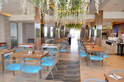 a restaurant with wooden tables and blue chairs at Elite Sea Sky Resort in Hurghada