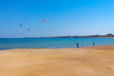 a group of people walking on the beach at Selena Bay Prime Stays in Hurghada