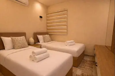 two beds in a room with towels on them at Selena Bay Prime Stays in Hurghada