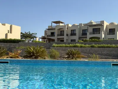 a swimming pool in front of some buildings at Makadi Heights Resort in Hurghada