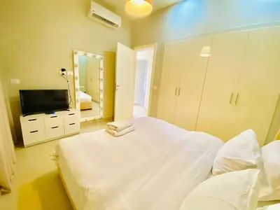 a bedroom with a large white bed and a mirror at Luxury villa twaila in Hurghada