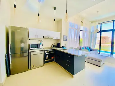 a kitchen with a stainless steel refrigerator and a couch at Luxury villa twaila in Hurghada