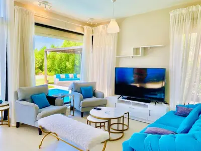 a living room with blue furniture and a large screen tv at Luxury villa twaila in Hurghada
