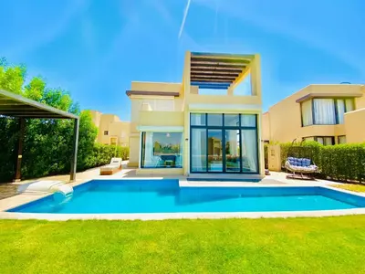 a villa with a swimming pool in front of a house at Luxury villa twaila in Hurghada