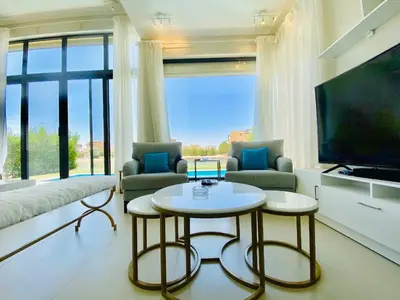 a living room with a table and a large window at Luxury villa twaila in Hurghada