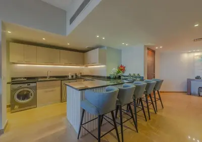 a kitchen with a bar with bar stools at Upscale 2BR Mosaique Marina Stay, Yachts & Sea Views in Hurghada
