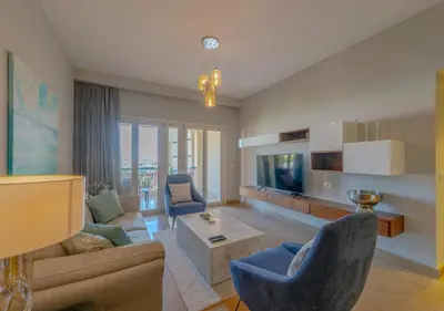 a living room with a couch and a tv at Upscale 2BR Mosaique Marina Stay, Yachts & Sea Views in Hurghada