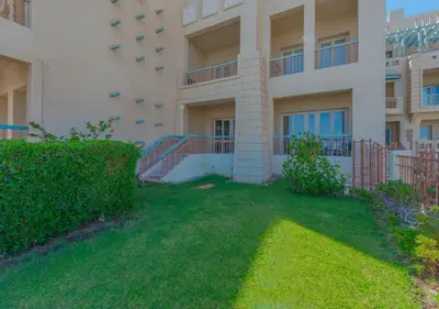 an apartment building with a yard in front of it at Upscale 2BR Mosaique Marina Stay, Yachts & Sea Views in Hurghada