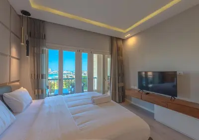 a bedroom with a large bed and a large tv at Upscale 2BR Mosaique Marina Stay, Yachts & Sea Views in Hurghada