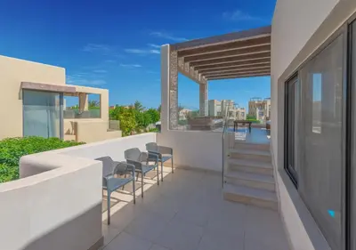 a balcony with chairs and stairs on a building at Airy & Bright 4BR Villa in Tawila, El Gouna, Private Pool & Lagoon Access in Hurghada