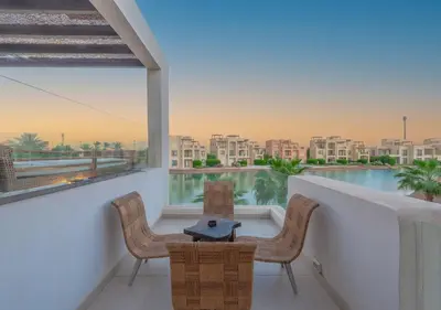 a balcony with two chairs and a table and a view at Airy & Bright 4BR Villa in Tawila, El Gouna, Private Pool & Lagoon Access in Hurghada