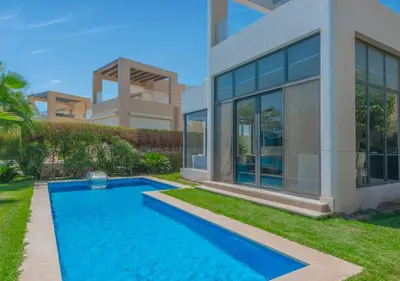 a swimming pool in front of a house at Airy & Bright 4BR Villa in Tawila, El Gouna, Private Pool & Lagoon Access in Hurghada