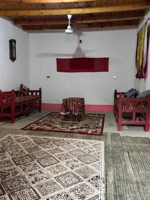 a room with two beds and a rug on the floor at Mountain house retreat in Al Aqālitah