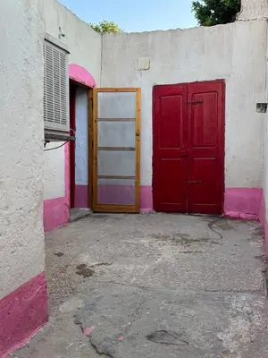 a red door and a white wall with a red door at Mountain house retreat in Al Aqālitah
