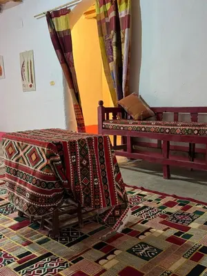 a room with two benches and a rug at Mountain house retreat in Al Aqālitah