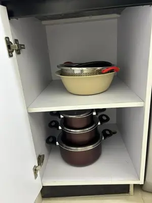 a cabinet with pots and pans on a shelf at شقة صغيرة جميلة امام مارينا الغردقة in Hurghada
