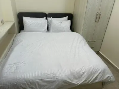 a large white bed with white sheets and pillows at شقة صغيرة جميلة امام مارينا الغردقة in Hurghada
