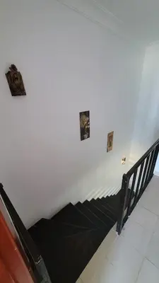 a staircase in a white wall with paintings on the wall at Amazing Douplex in The View in Hurghada