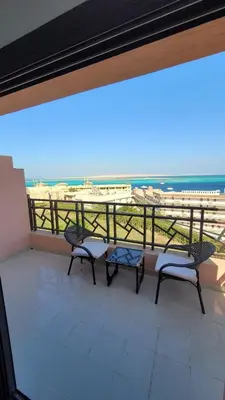 a balcony with two benches and a view of the beach at Amazing Douplex in The View in Hurghada
