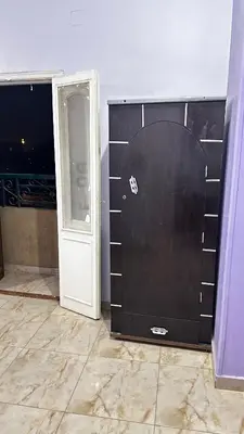 a room with a black door and an open doorway at Diebo in Aswan